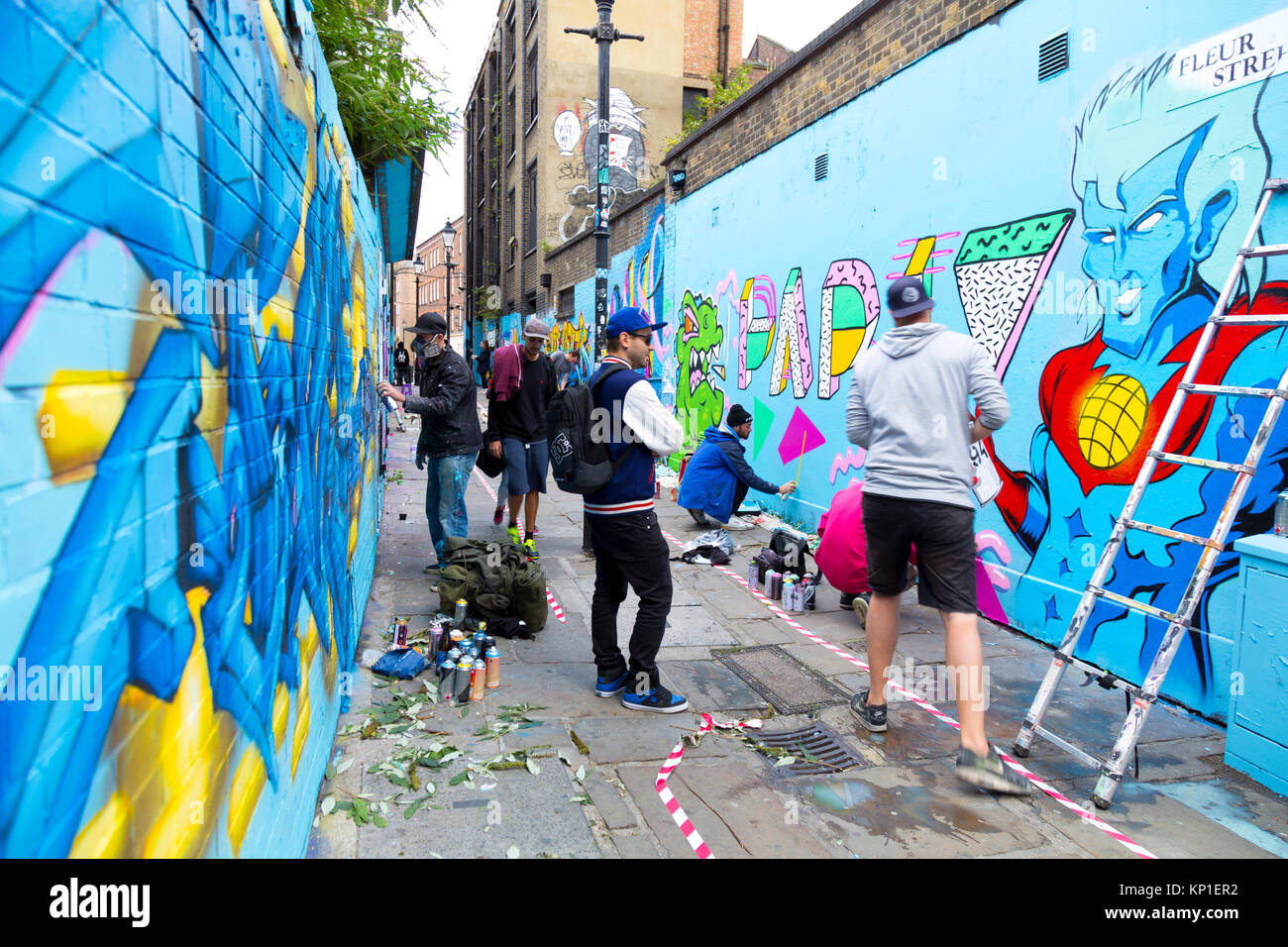 Les artistes de rue Graffiti les murs de pulvérisation en Fleur Street, London, UK Banque D'Images