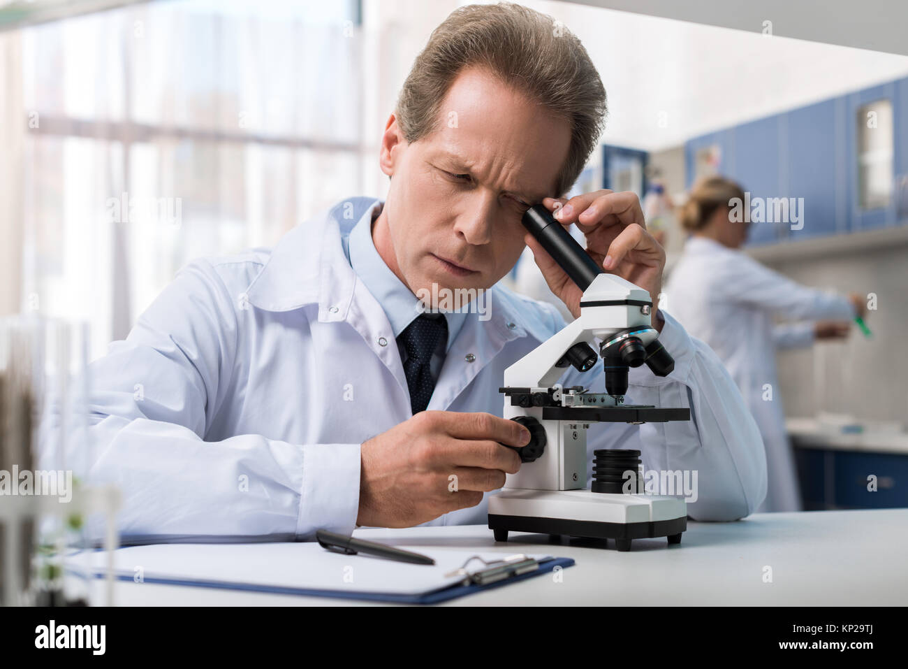 Chemist working with microscope Banque D'Images