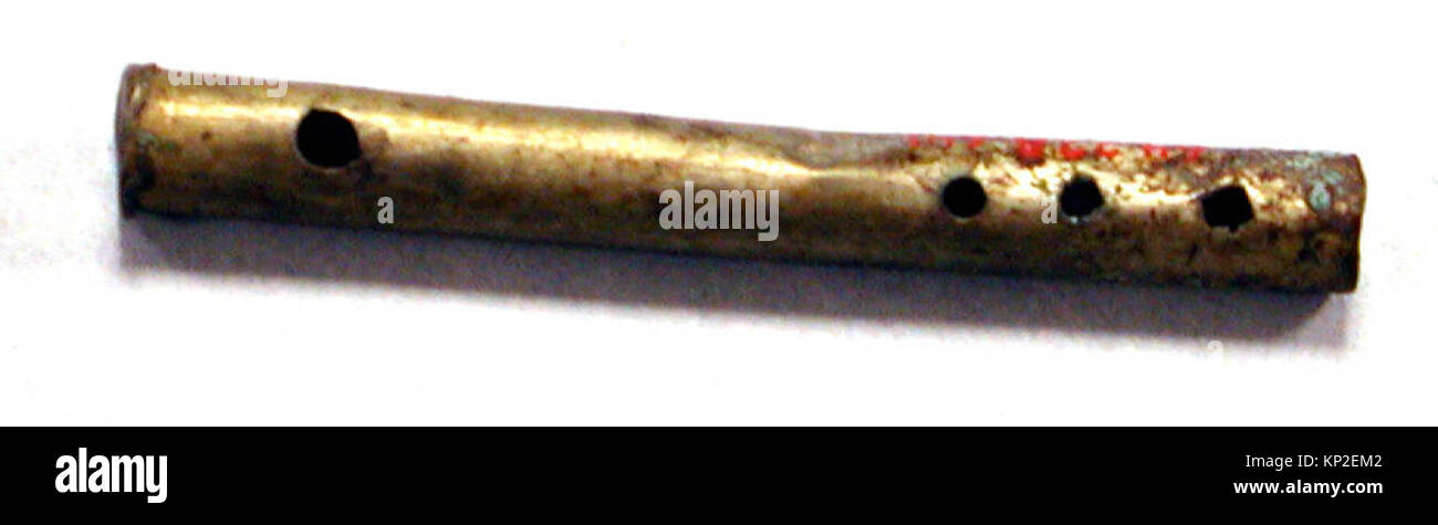 Une petite flûte argentée martelée, dotée d'un corps tubulaire et d'une métallurgie détaillée. Cette pièce illustre l'artisanat traditionnel dans les instruments de musique décoratifs. Banque D'Images