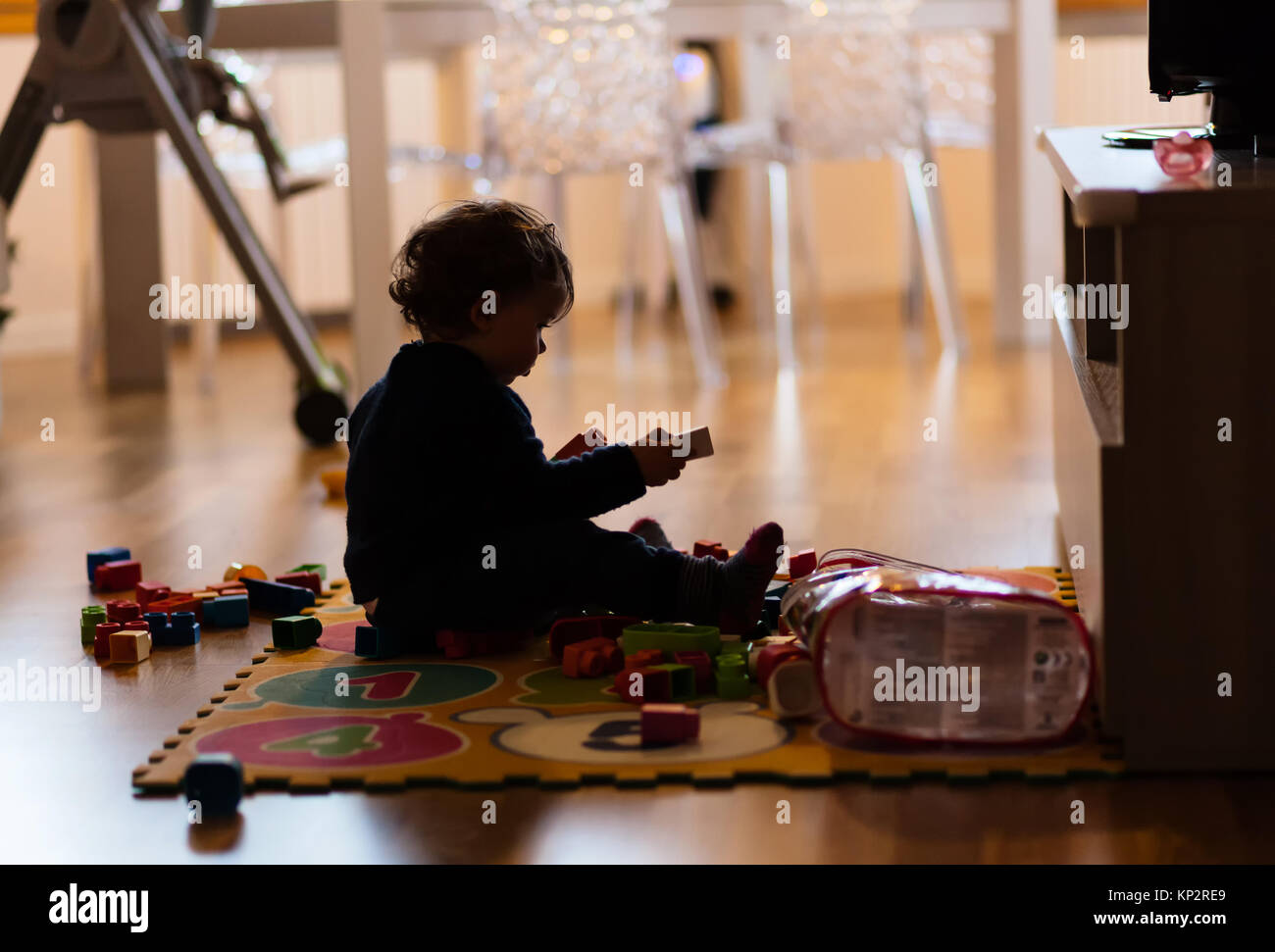 Bébé Enfant fille jouant avec des jouets à la maison. Photo prise dans l'objet avec rétroéclairage en silhouette. Banque D'Images