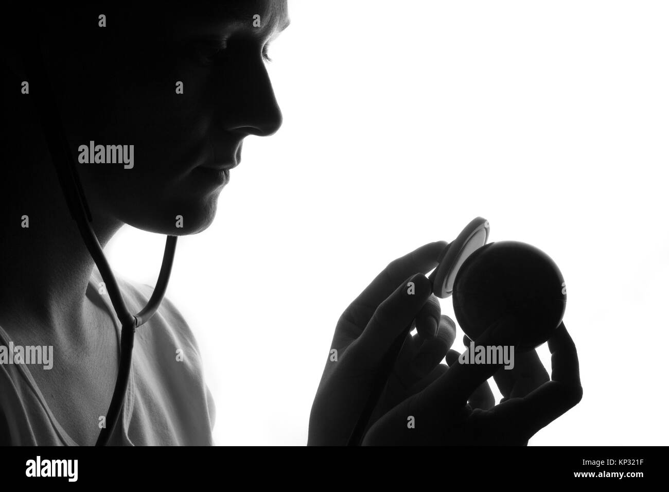 Silhouette d'un jeune homme à l'écoute et le sentiment de l'espace du cercle avec un stéthoscope. Le sentiment d'amour et de soins à propos de concept Monde Banque D'Images