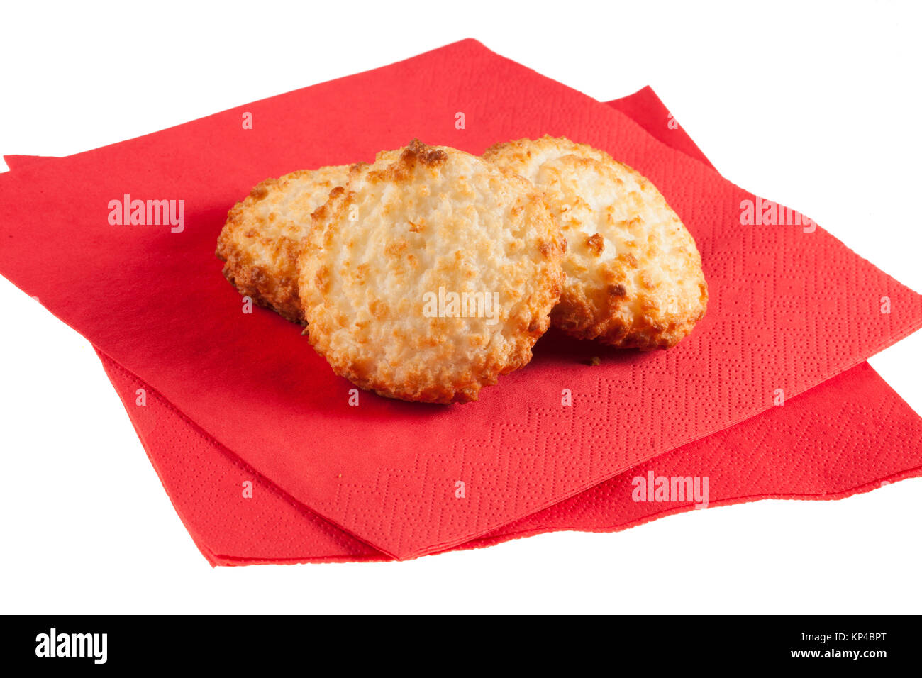 Trois macarons sur des serviettes de table rouges sur fond blanc, Banque D'Images