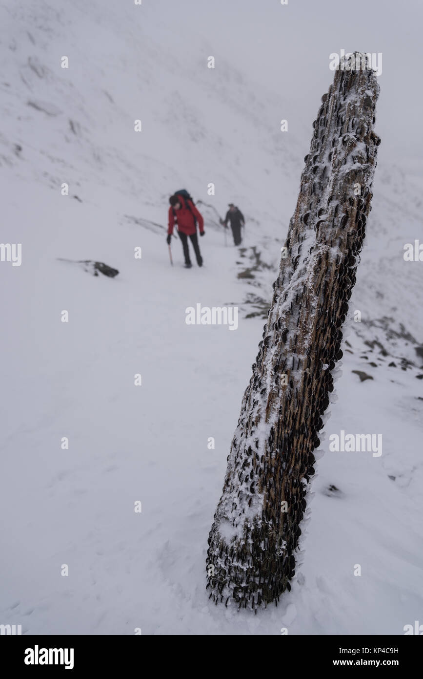 Figure dans les montagnes enneigées de l'ACEP, Snowdonia, retraite aux flambeaux, sac à dos d'alpinisme Banque D'Images