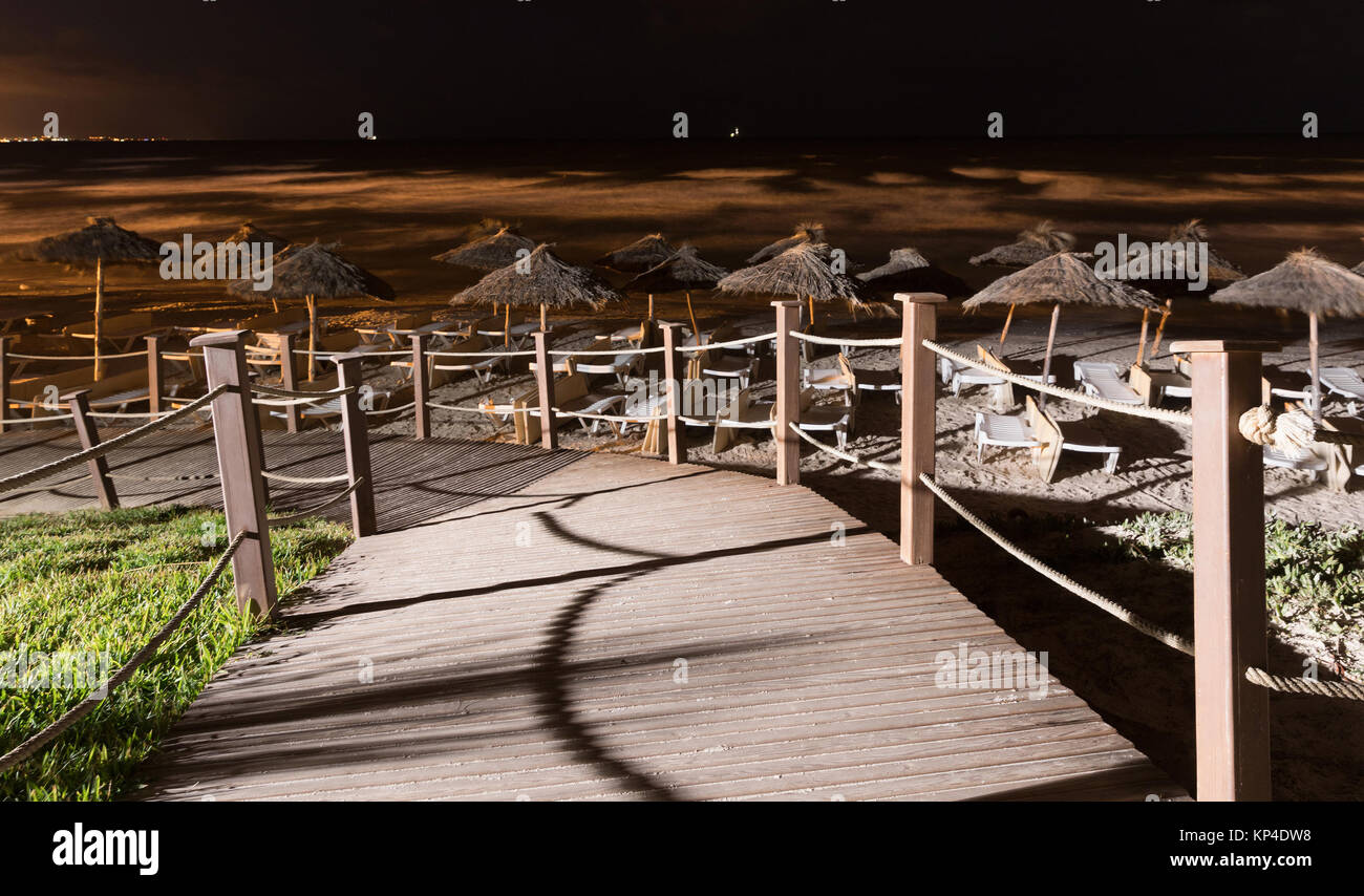 Plage le soir. Chemin de plage en bois, vue de nuit sur une belle plage par la mer. Soirée romance de la mer. Banque D'Images