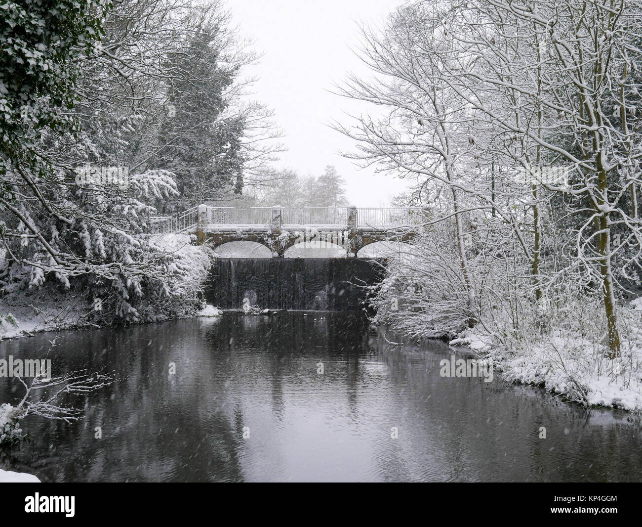 Scène hivernale : Pont sur la rivière Dove, sur un jour de neige dans le village de Rolleston sur Colombe, Staffordshire Banque D'Images