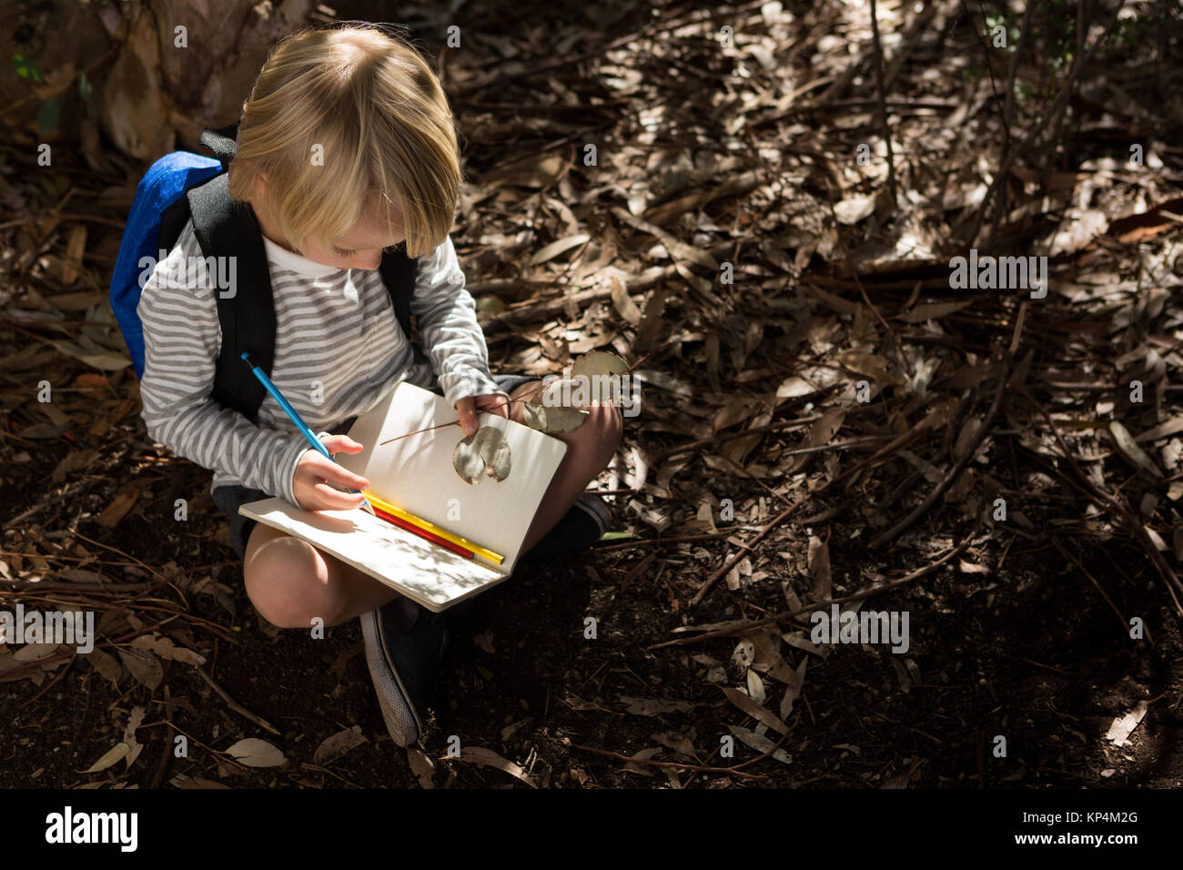 Sur la tête de la petite fille assise sur le sac à dos avec motif écrit dans l'ordinateur portable Banque D'Images