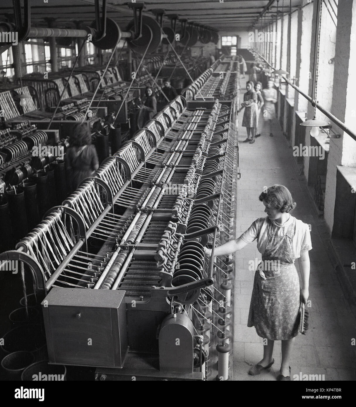 Années 1950, historique, l'image montre des rangées de machines à tisser mécanisés, les coopératives de femmes et l'un des nettoyeurs de femelle avec un pinceau dans la main. inspeecting les métiers, de l'Irlande du Nord. Banque D'Images