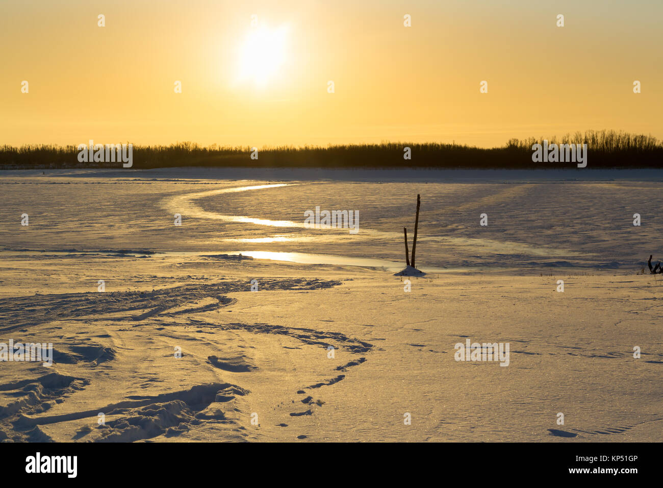 Lever du soleil sur la rivière couverte de glace et de neige Banque D'Images