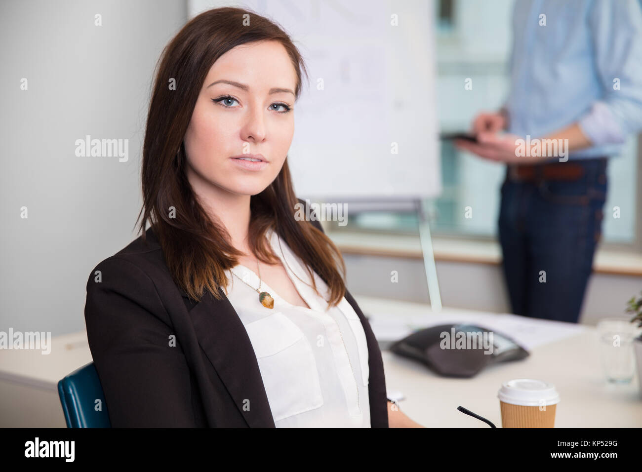 Confident Businesswoman Sitting At Desk In Office Banque D'Images