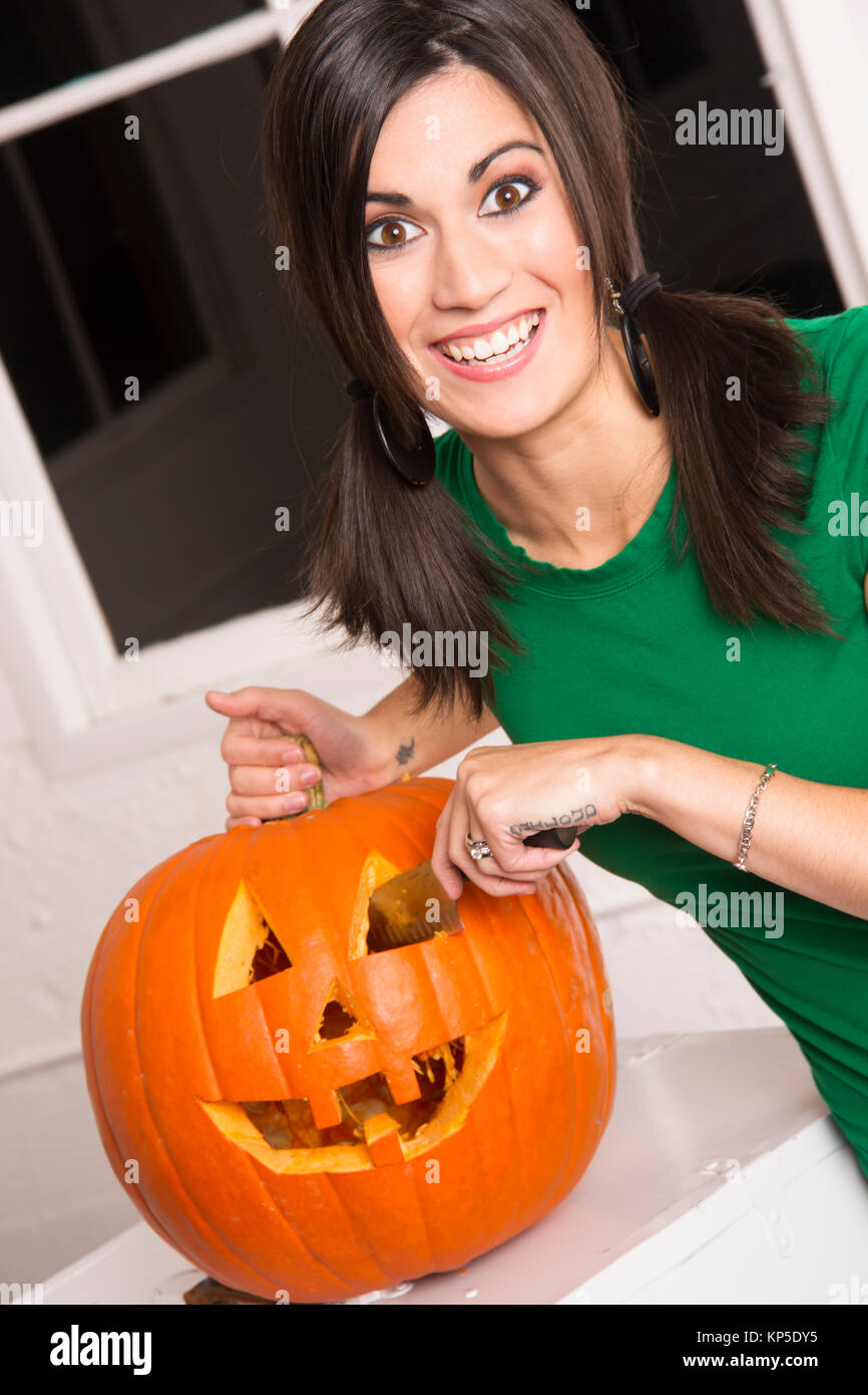 Heureux Happy Woman Cutting Carving Halloween citrouille Jack-O-Lantern Banque D'Images