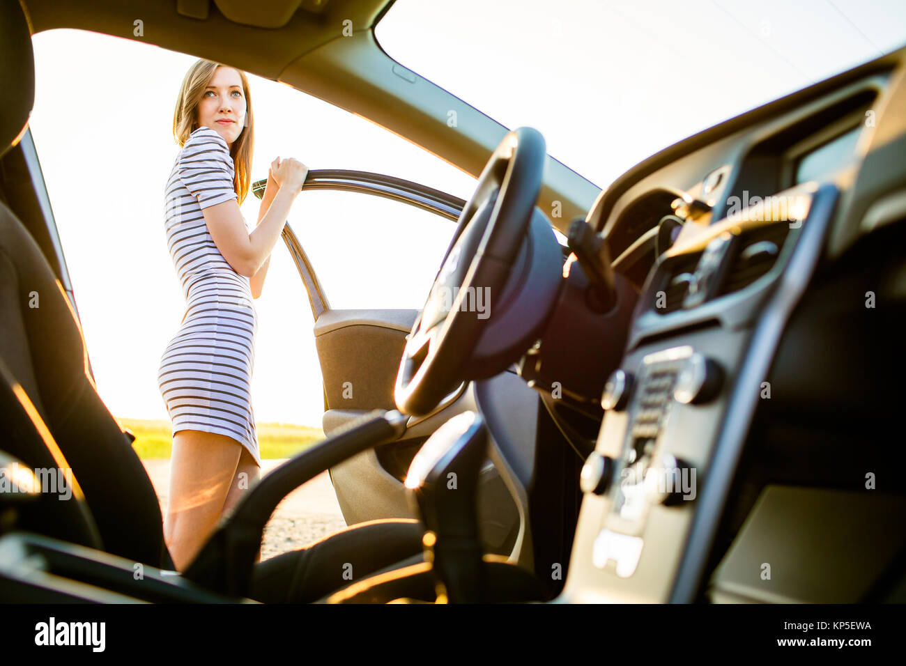 Portrait d'une jolie femme, pilote de l'adolescence, par sa nouvelle voiture Banque D'Images