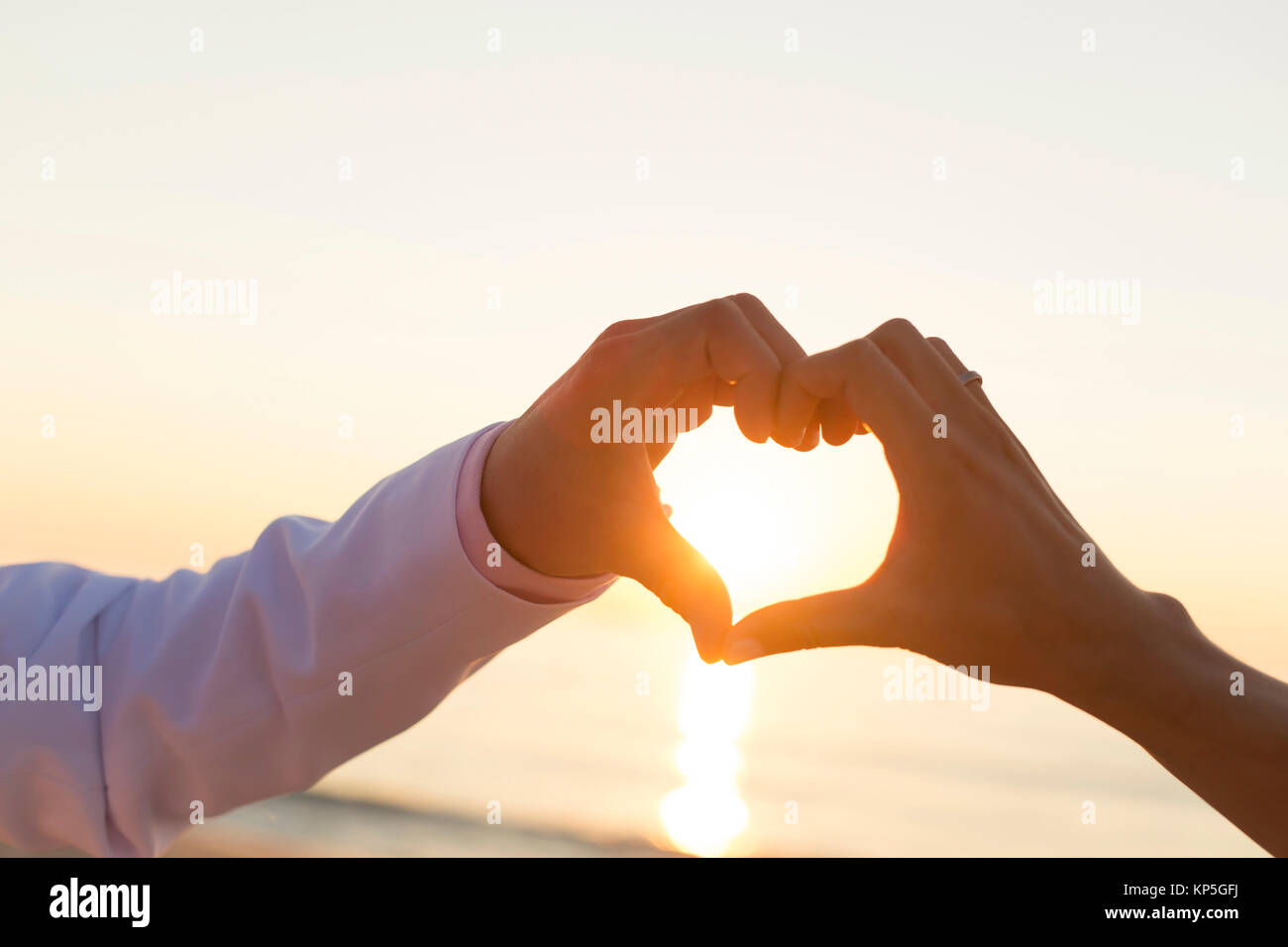 Sonnenaufgang am Strand, Paar mit Herz version Haenden - coucher de soleil à la plage, un couple fait un coeur avec les mains Banque D'Images