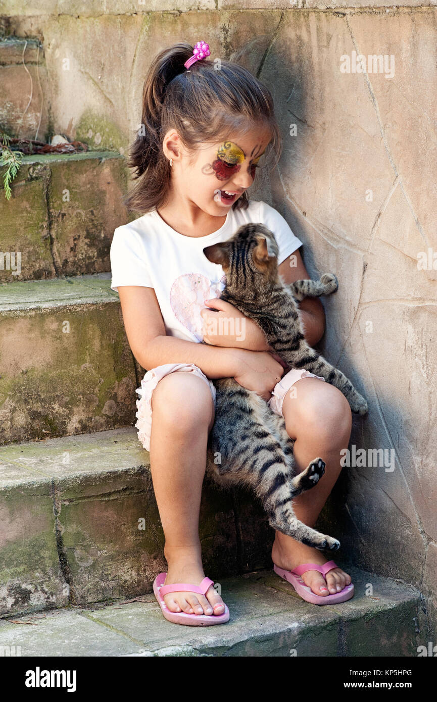Little girl hugging cat Banque D'Images