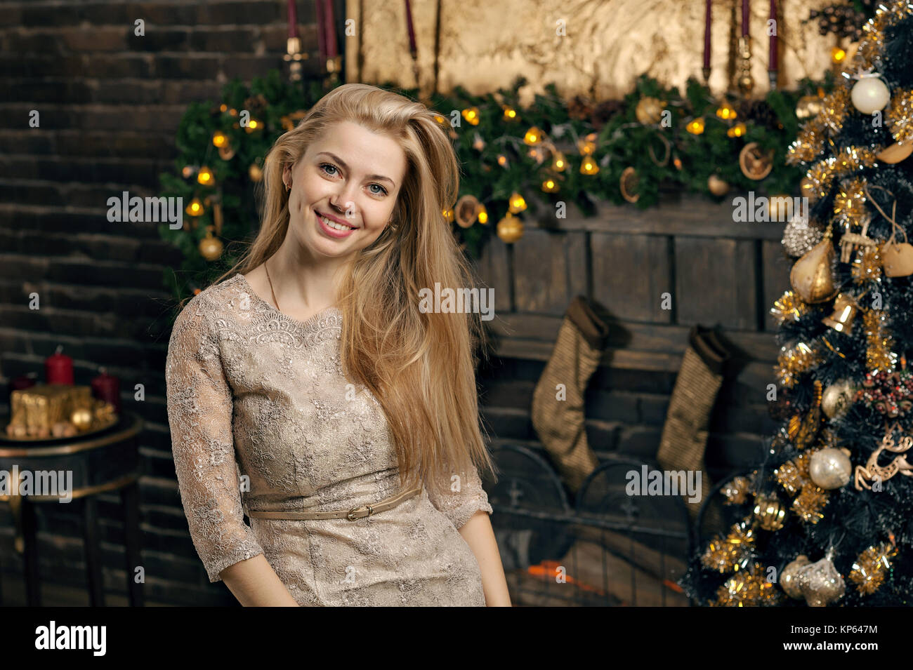 Jeune femme dans un intérieur chaleureux de Noël. La jeune fille est assise sous un arbre de Noël parmi de nombreux cadeaux. La préparation de Noël. Le concept d'une maison de vacances Banque D'Images