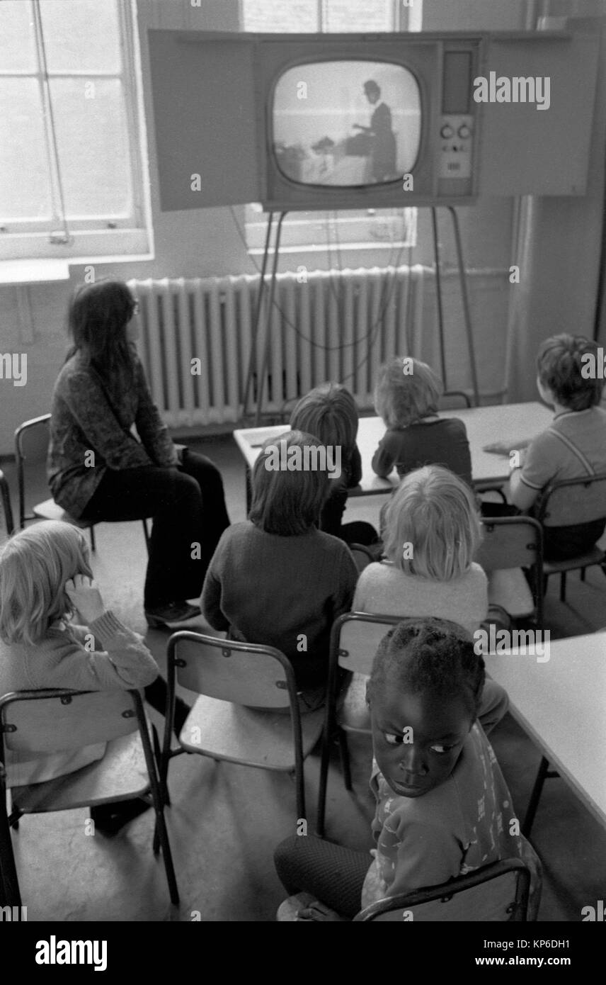 École primaire des enfants des années 1970 regardant la télévision en classe. La télévision de l'école sur un stand pour que tout le monde puisse voir. Le professeur de l'école est assis à l'avant. Jeune fille britannique noire se retournant, multi ethnique Angleterre 1972 UK HOMER SYKES Banque D'Images