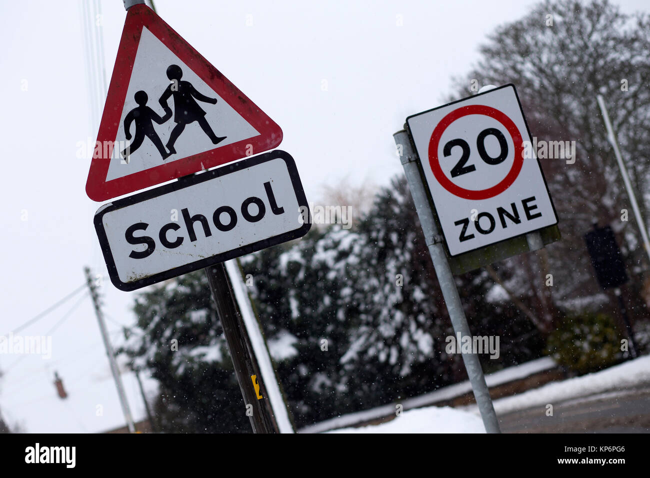 Des signes d'avertissement pour une école, et une limite de 20 mph dans la neige dans la zone,Bugbrooke Northamptonshire Banque D'Images