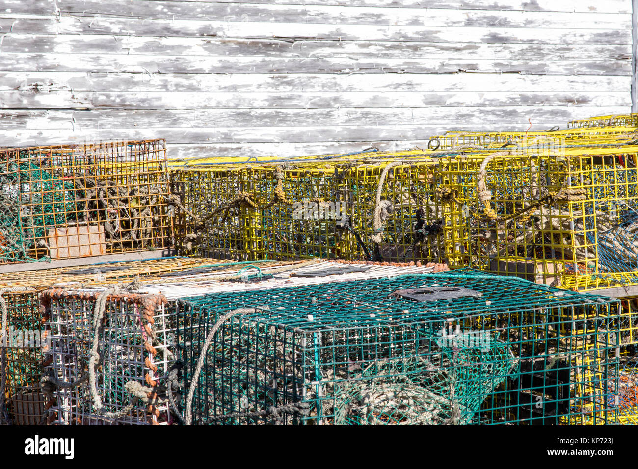 Des casiers à homard empilés à côté du hangar en bois rustique situé sur le bord de mer. Banque D'Images