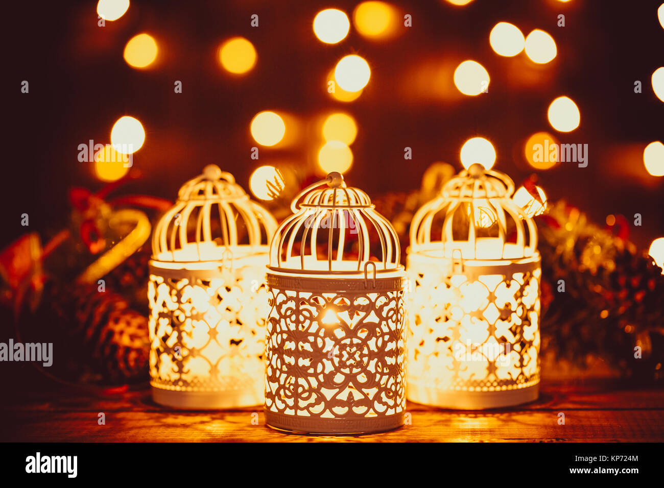 Noël lanterne avec brûler des bougies et de la guirlande sur vintage table en bois avec bokeh d'or. Espace libre Banque D'Images