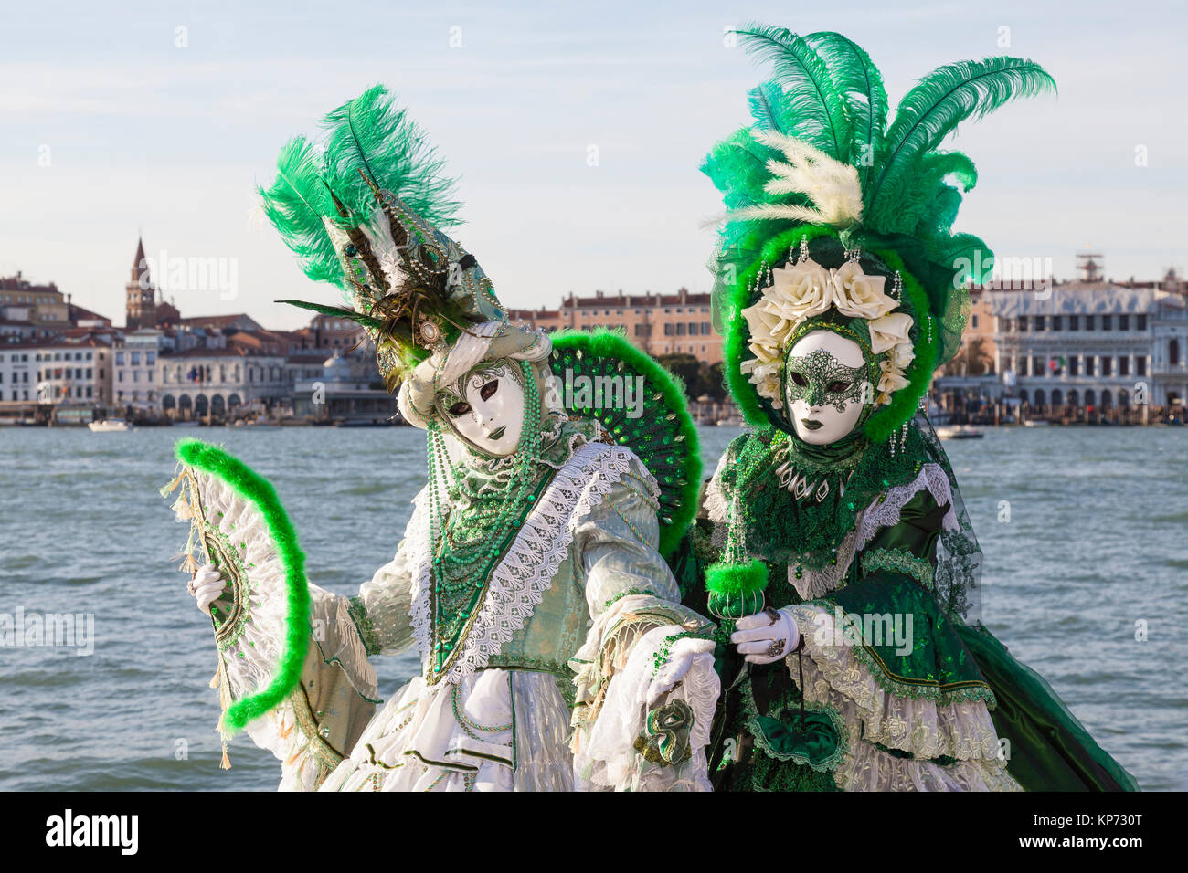 Carnaval de Venise, Vénétie, Italie. Deux femmes en costume vert classique  et des masques qui posent ensemble à la lagune au coucher du soleil Photo  Stock - Alamy