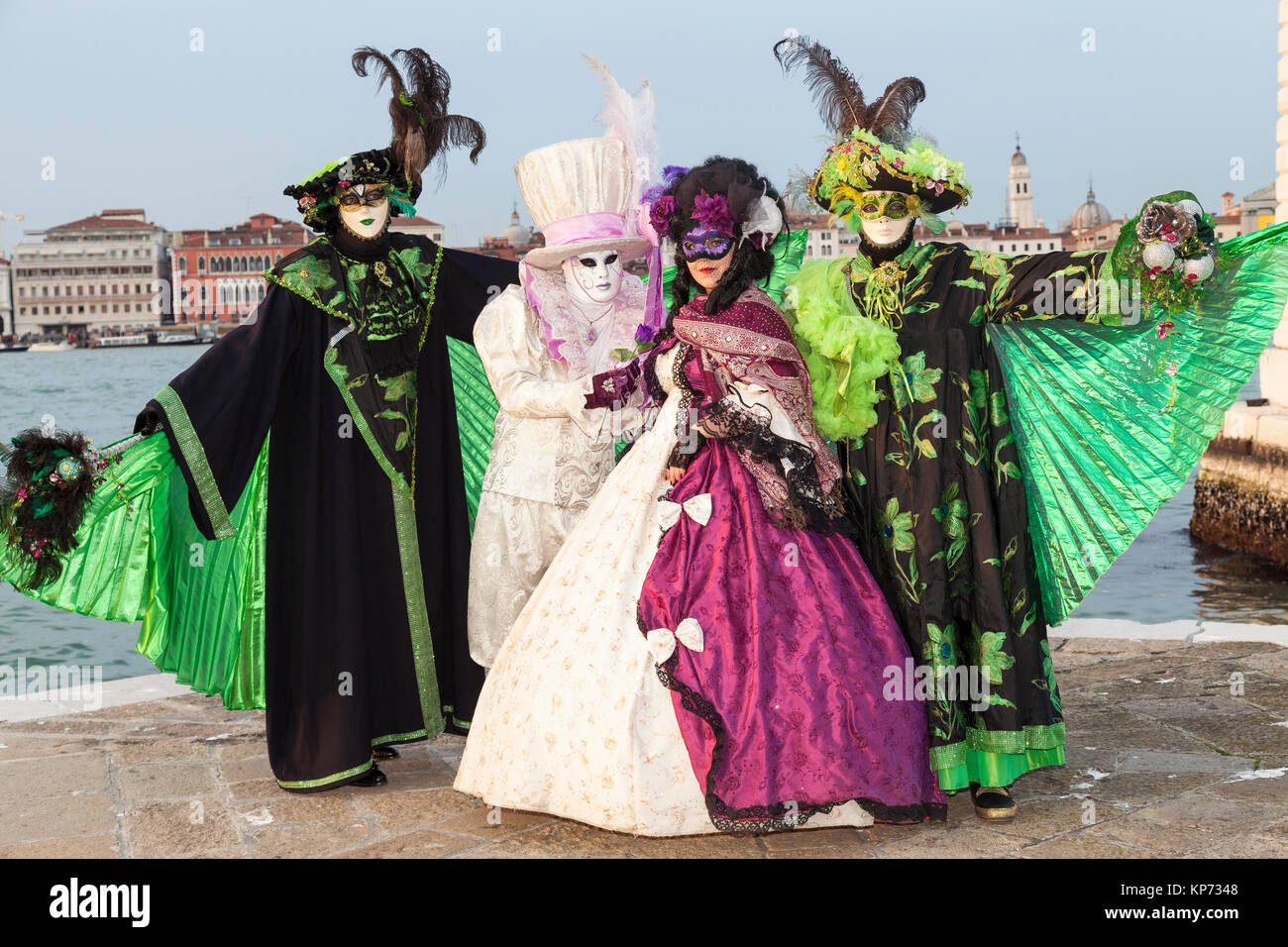 Carnaval de Venise, Vénétie, Italie 2017 groupe de quatre posant au coucher du soleil en face de la lagune Banque D'Images