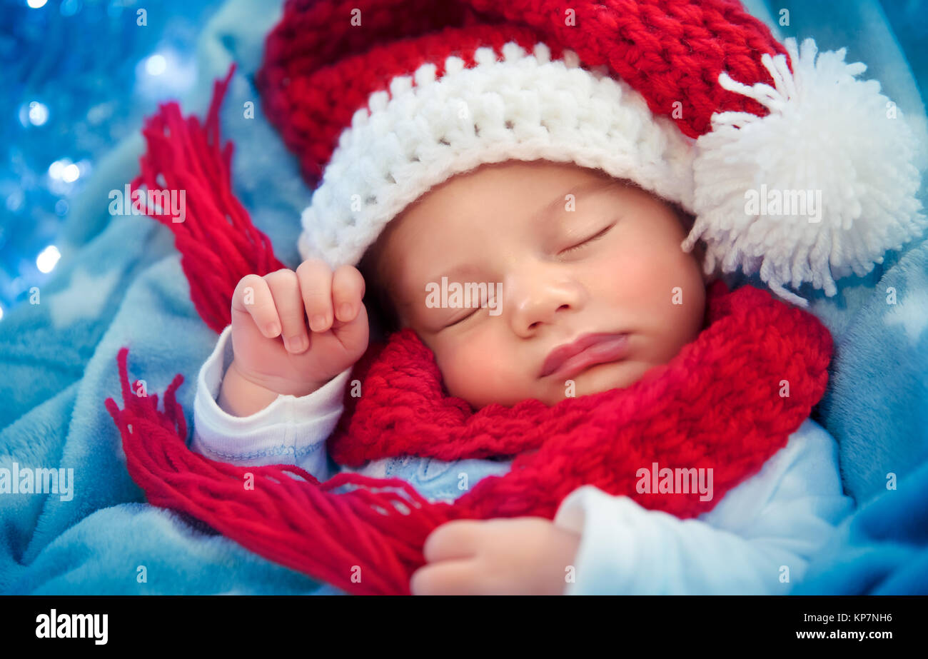 Portrait of a cute newborn baby wearing Santa hat tricoté rouge, dormir à la maison, heureux, joyeux Noël concept Banque D'Images