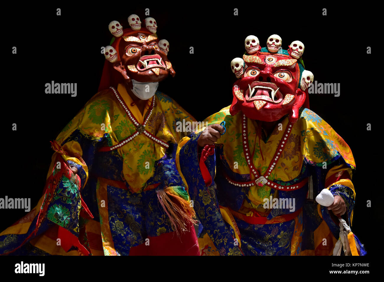Bourgogne rouge et deux costumes rituel de Mahakala tibétain ancien, des masques en bois avec bouche nue, long crocs et petits crânes humains en haut, monaster Banque D'Images