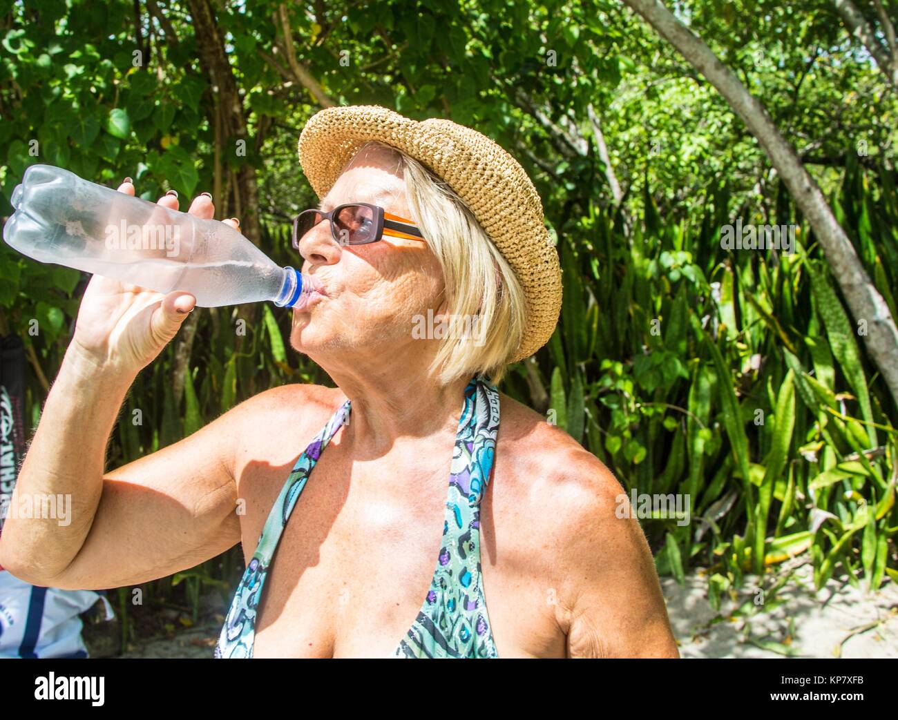 Retraités âgés caucasian woman l'eau potable à la plage dans son maillot de  bain, dans l'île tropicale de la Martinique Photo Stock - Alamy