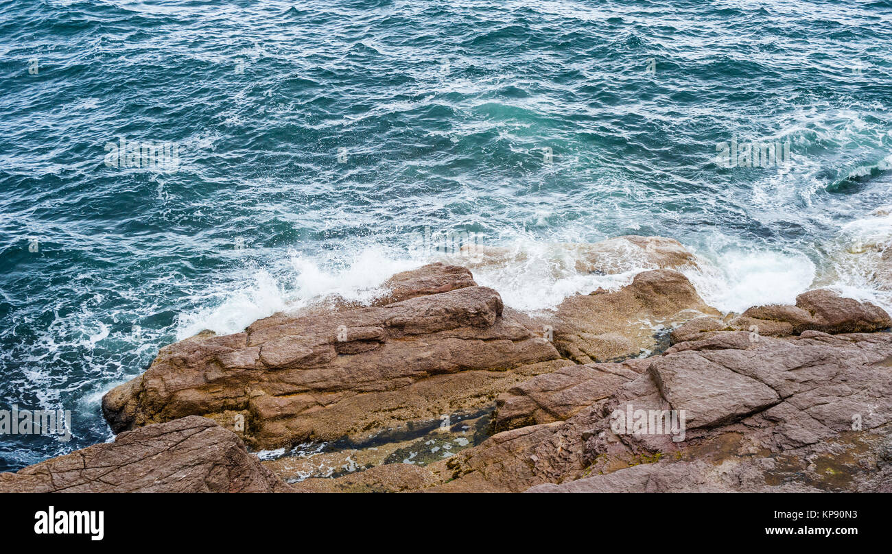 Éclaboussures des vagues de l'océan se briser contre les roches nues Banque D'Images