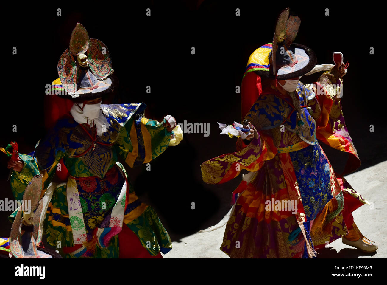 Deux moines indiens effectuer un rituel sacré dans des vêtements tibétains et d'énormes chapeaux noirs avec des crânes, Zanskar, Inde du Nord. Banque D'Images