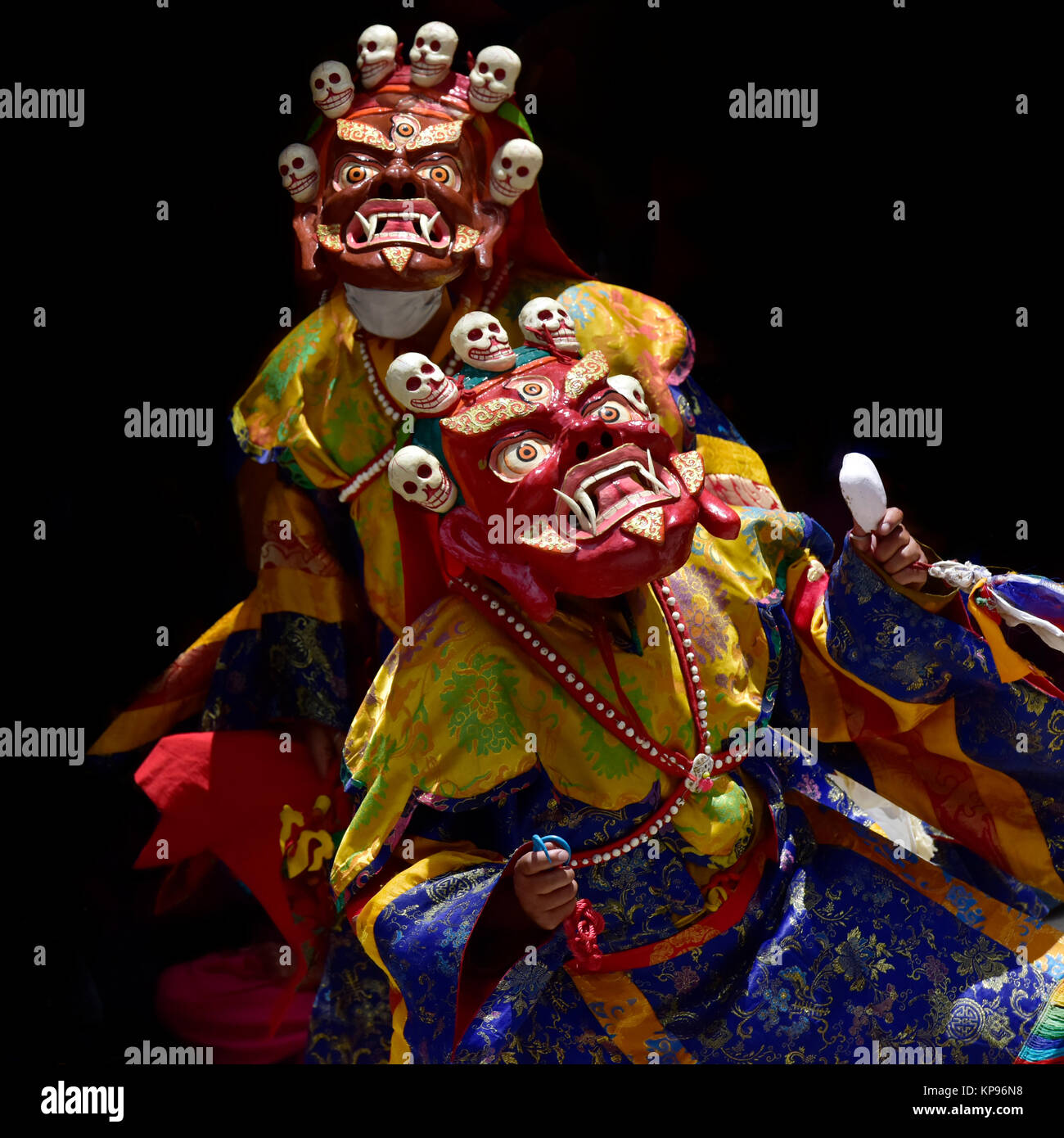 Les moines bouddhistes dans l'ancienne Mahakala rouge crânes des masques avec sur le dessus de la danse Cham rituel masque effectuer, Zanskar, Inde du Nord. Banque D'Images