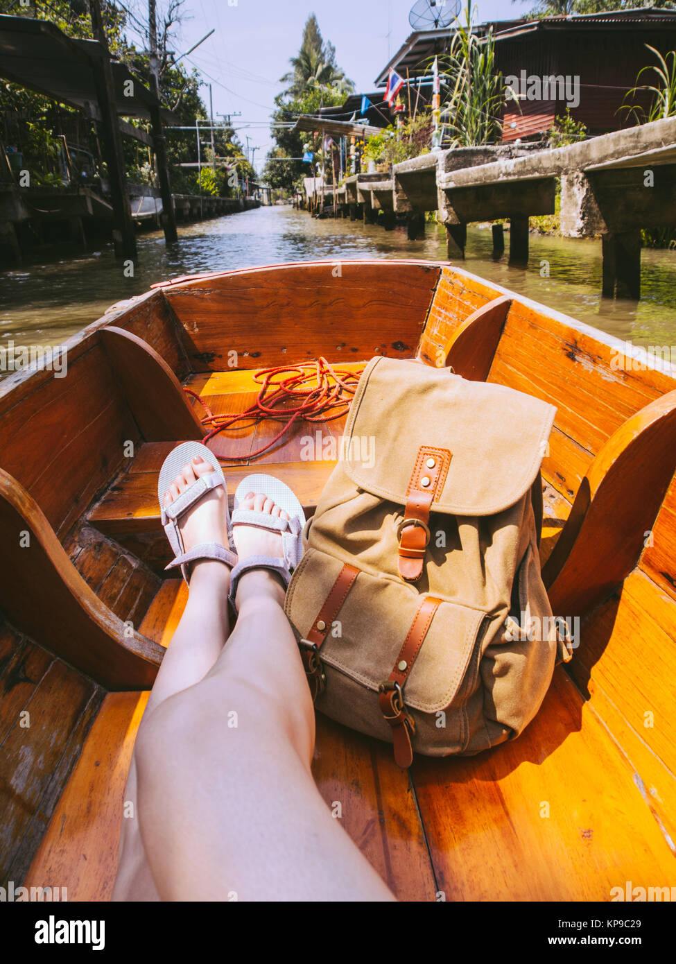 Longues jambes portaient des sandales chaussures femme assis sur un bateau  avec une bagagerie sac à dos et profiter de la vue locale marché flottant  en Thaïlande pendant les va Photo Stock -