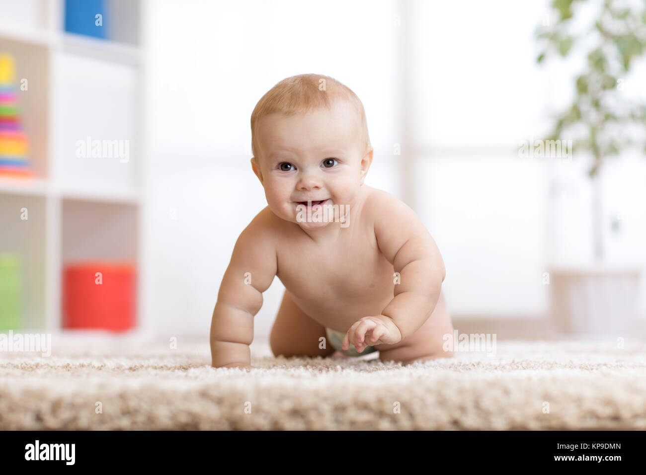 Adorable bébé ramper sur le tapis moelleux à la maison Banque D'Images