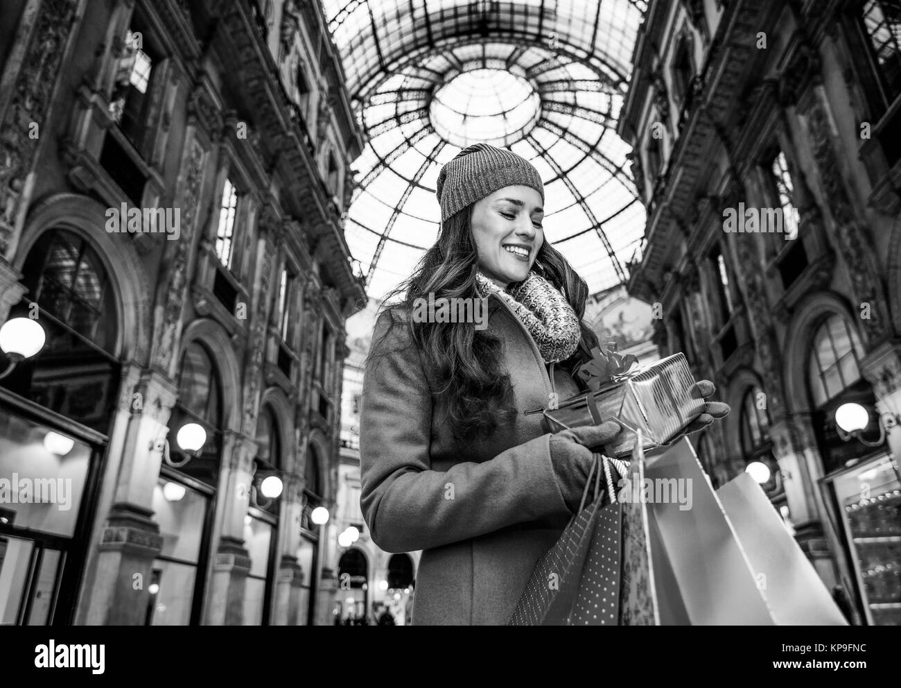 Sur une énorme vente de Noël dans la capitale italienne de la mode. Portrait of smiling woman with shopping bags modernes dans la galerie Vittorio Emanuele II à Milan, je Banque D'Images