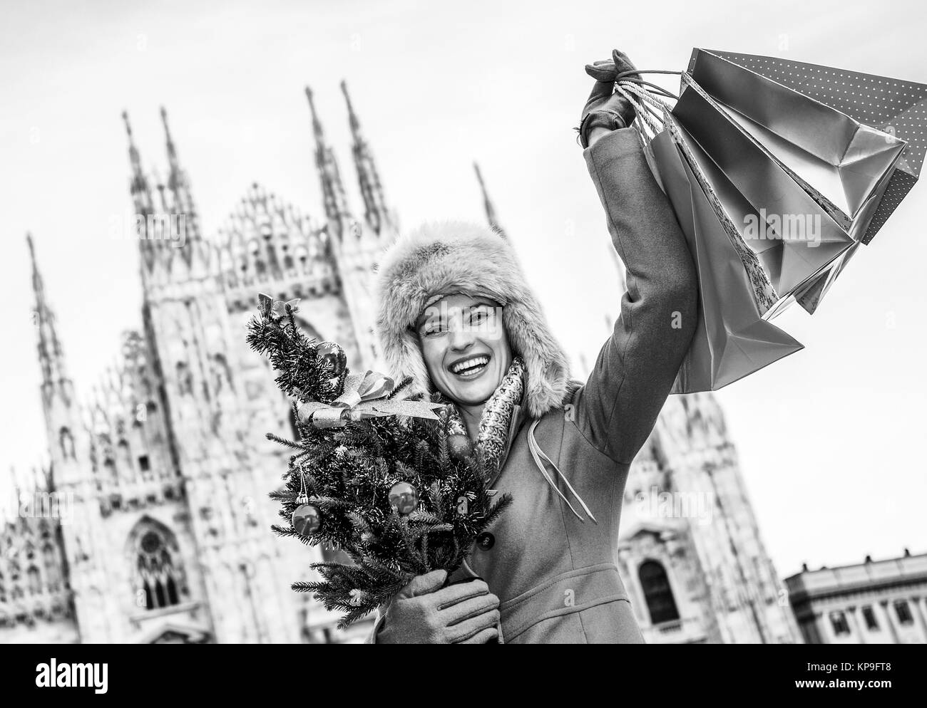 Noël amusant voyage à Milan, Italie. heureux jeune voyageur femme à Milan, Italie avec arbre de Noël et les sacs se réjouir Banque D'Images