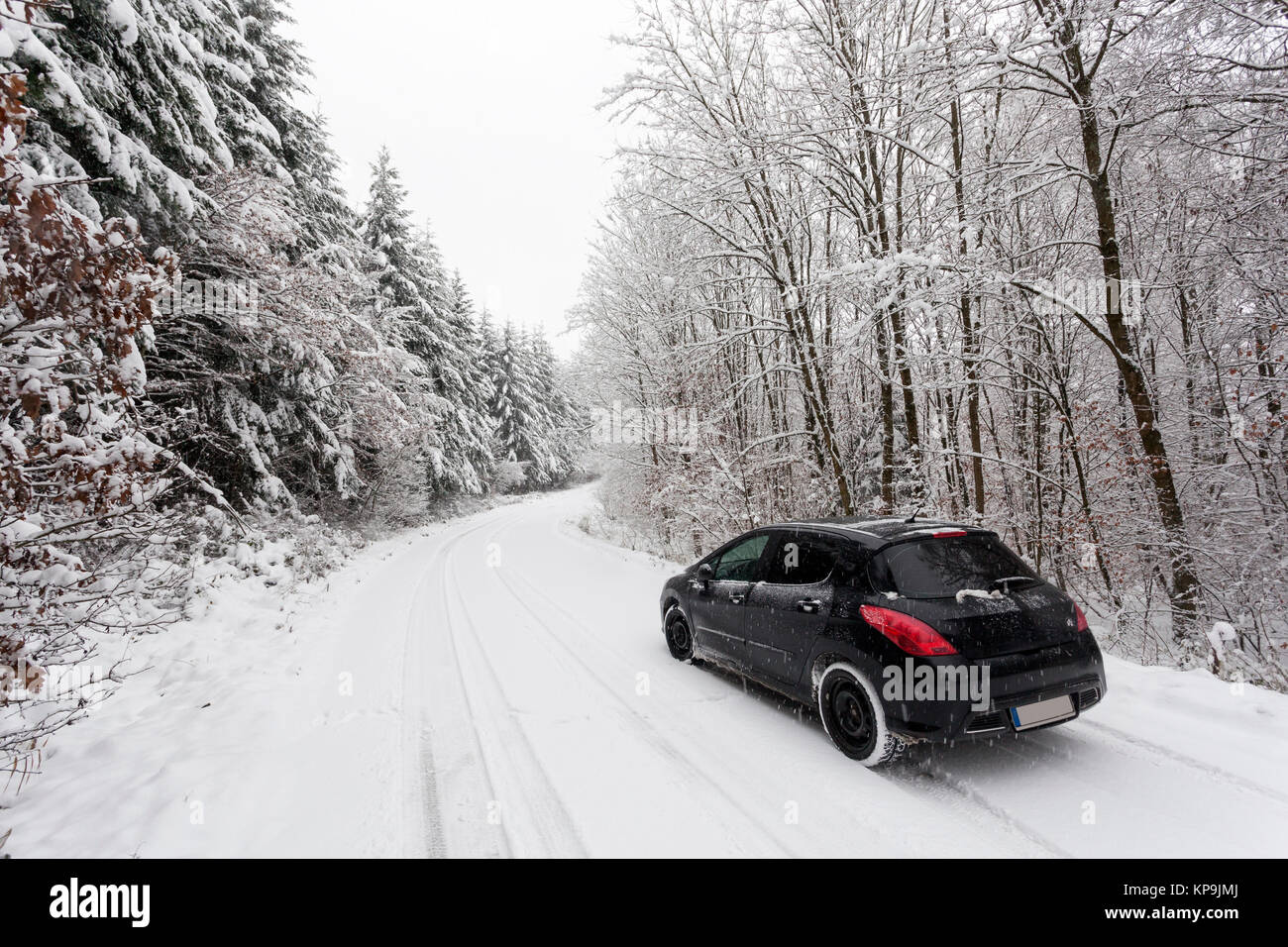 Voiture sur une route couverte de neige dans une forêt d'hiver blanc neige en Allemagne Banque D'Images