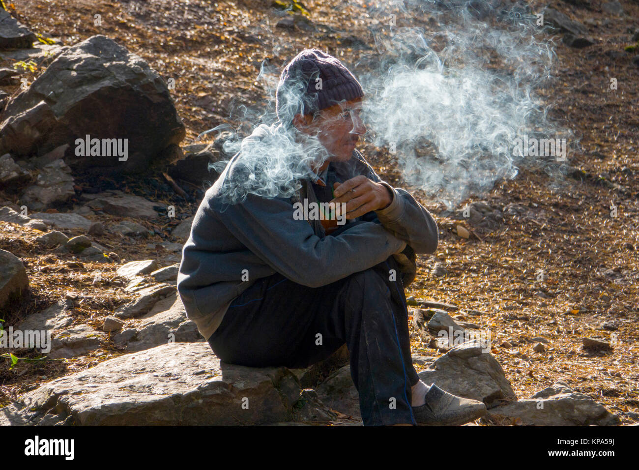 L'homme indien est assis cigarette dans Dharamkot, Inde Banque D'Images