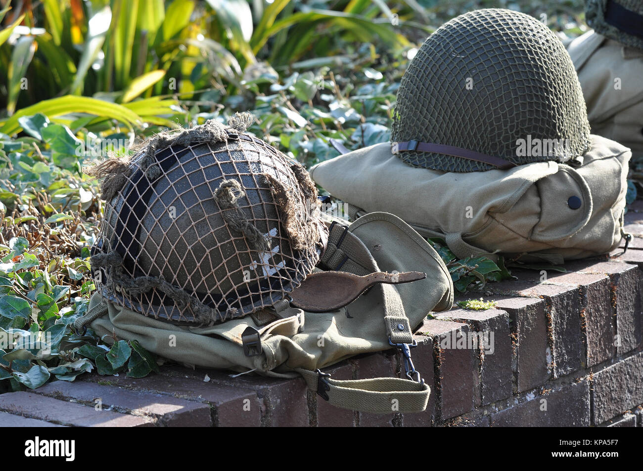Casques et packs de l'armée américaine de seconde Guerre mondiale placés sur un mur à un service commémoratif pour les anciens combattants de la Journée D. Commémoration. Honorant. Équipement de combat Banque D'Images