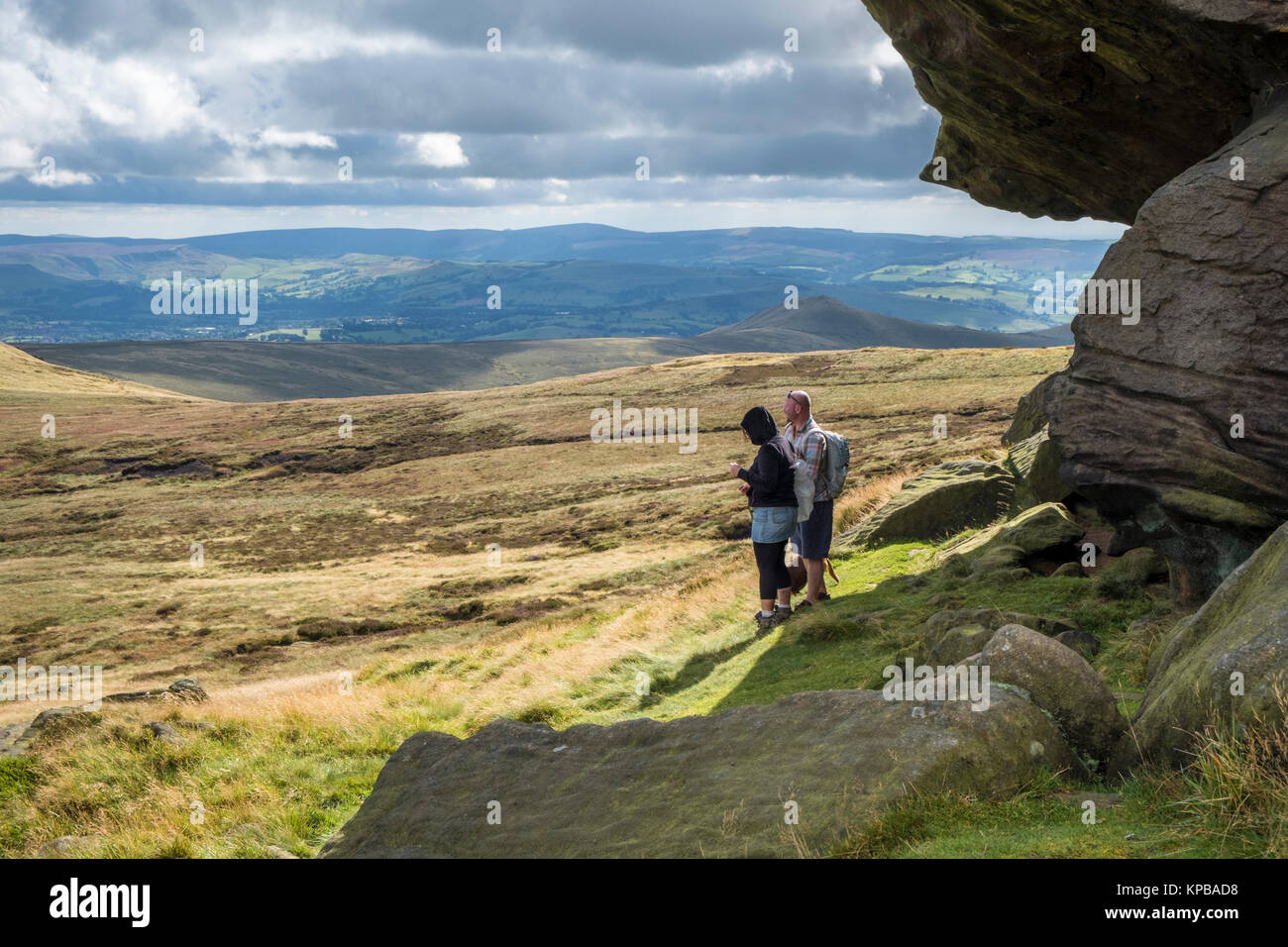 Les marcheurs près de Edale Rocks en observant le paysage de lande et de la vue panoramique sur la campagne, Kinder Scout, Derbyshire Peak District, England, UK Banque D'Images