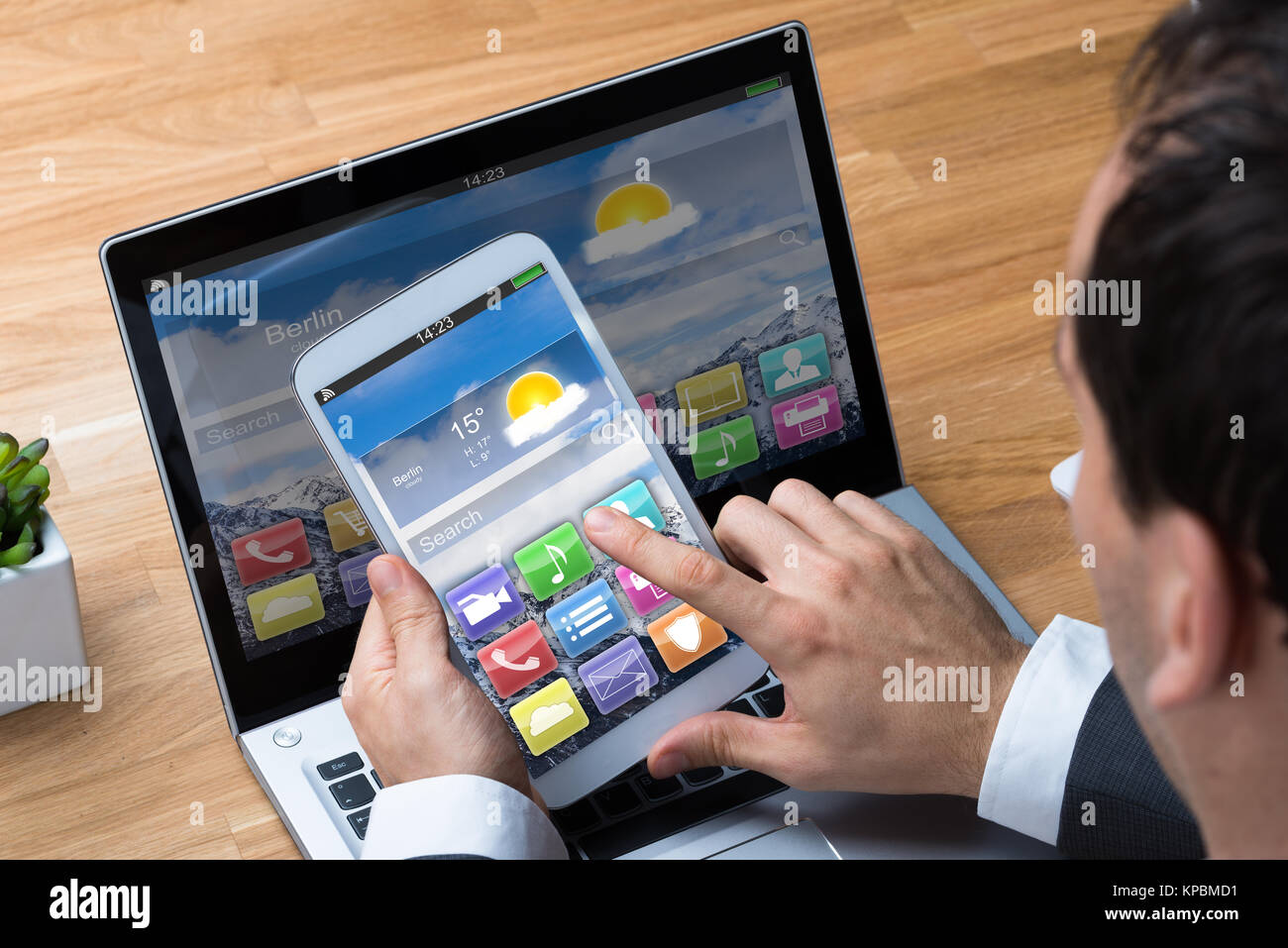 Businessman Using Smartphone et Laptop At Desk Banque D'Images