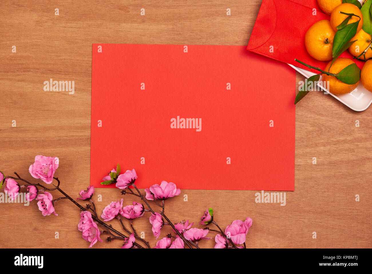 Haut afficher les accessoires le festival du Nouvel an chinois.décorations,orange,feuilles,panier Bois de prunier,paquet rouge sur fond rouge. Banque D'Images