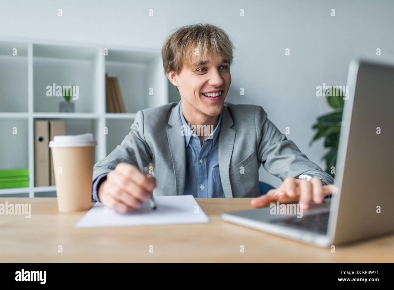 Smiling businessman working at laptop Banque D'Images