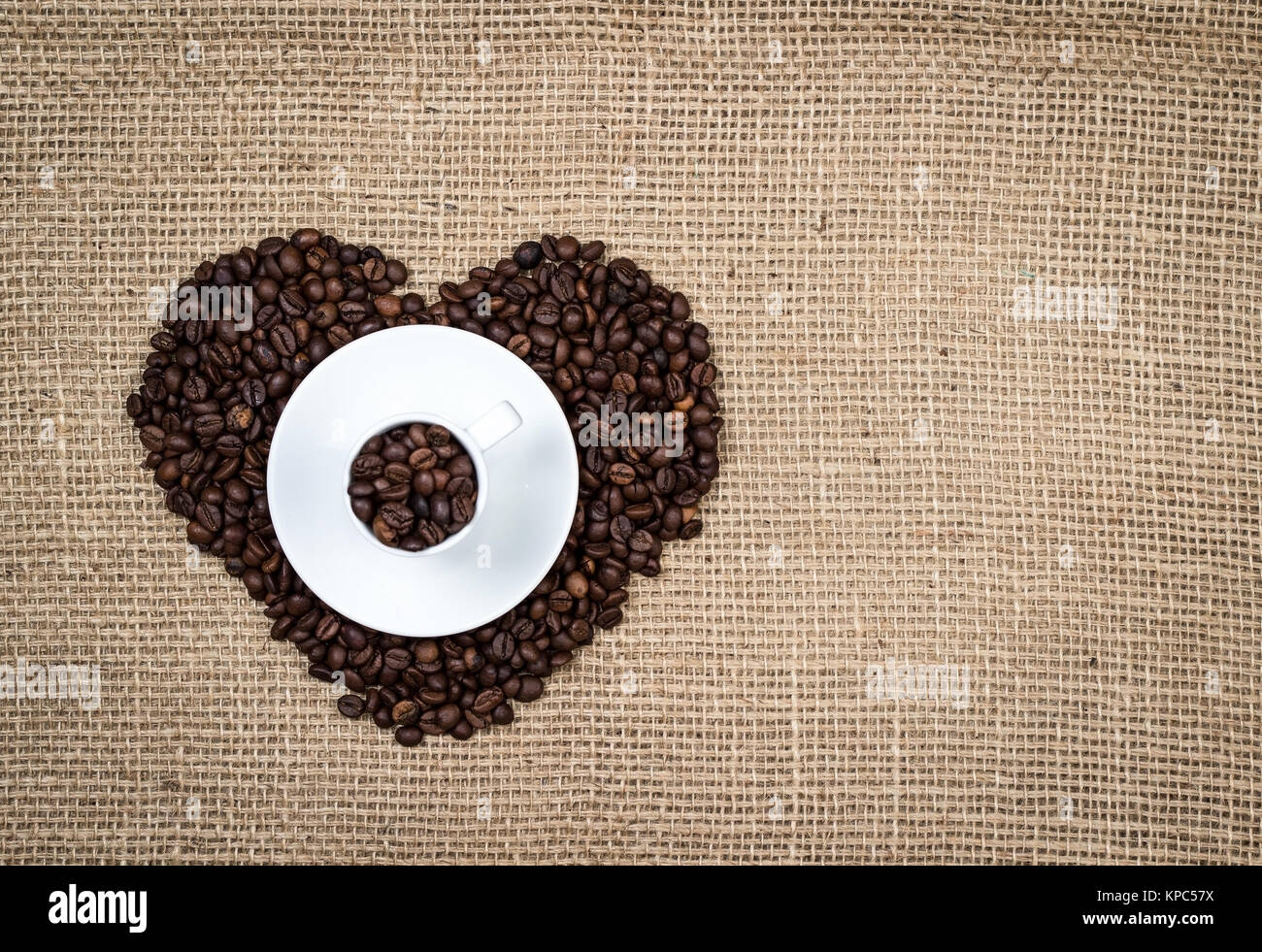 Tasse blanche sur les grains de café coeur Banque D'Images