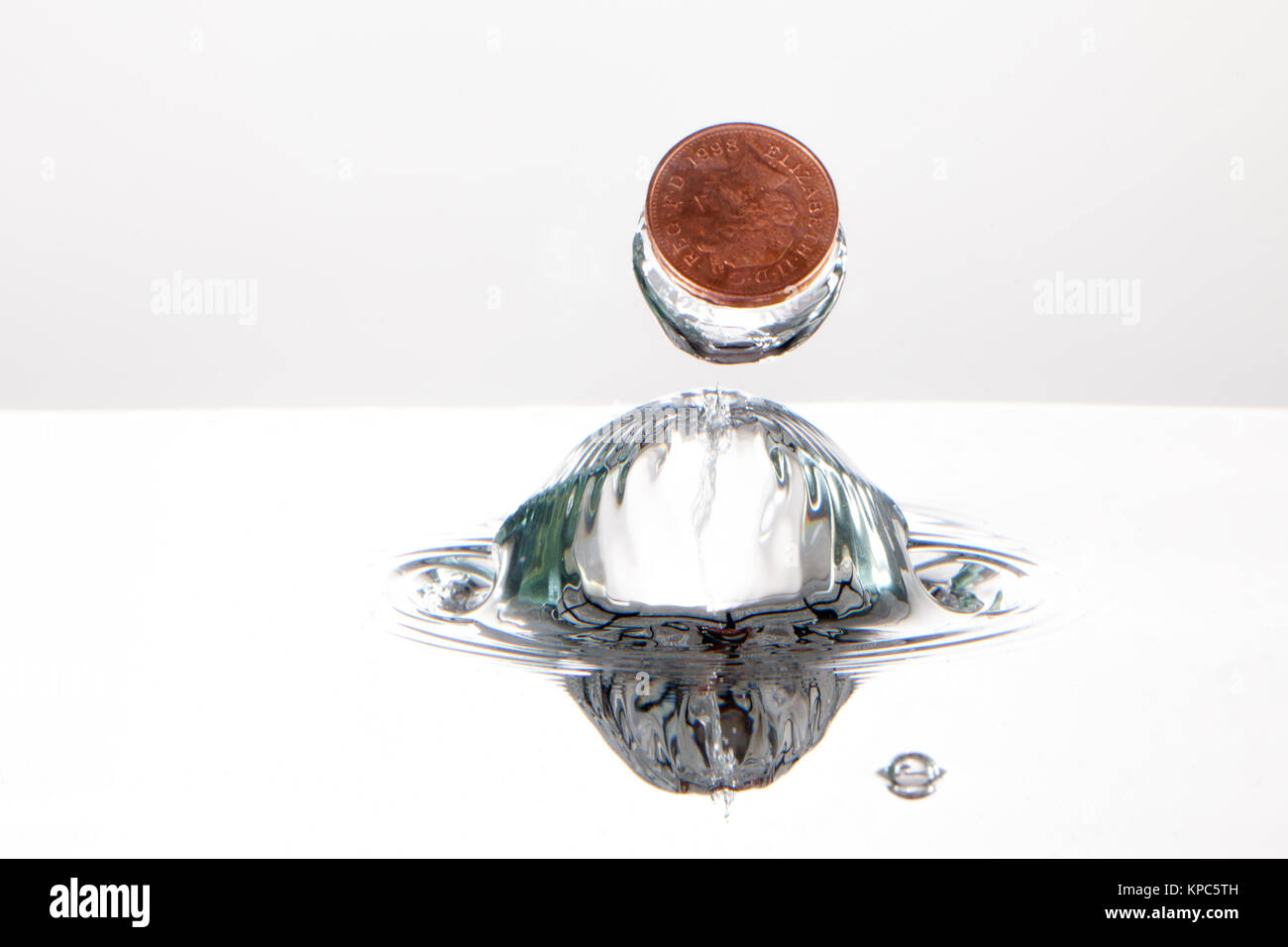 Coin splash dans l'eau pris avec la photographie à grande vitesse, sur un fond blanc Banque D'Images