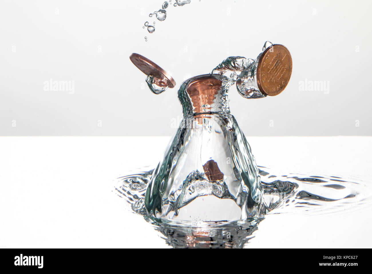 Coin splash dans l'eau pris avec la photographie à grande vitesse, sur un fond blanc Banque D'Images