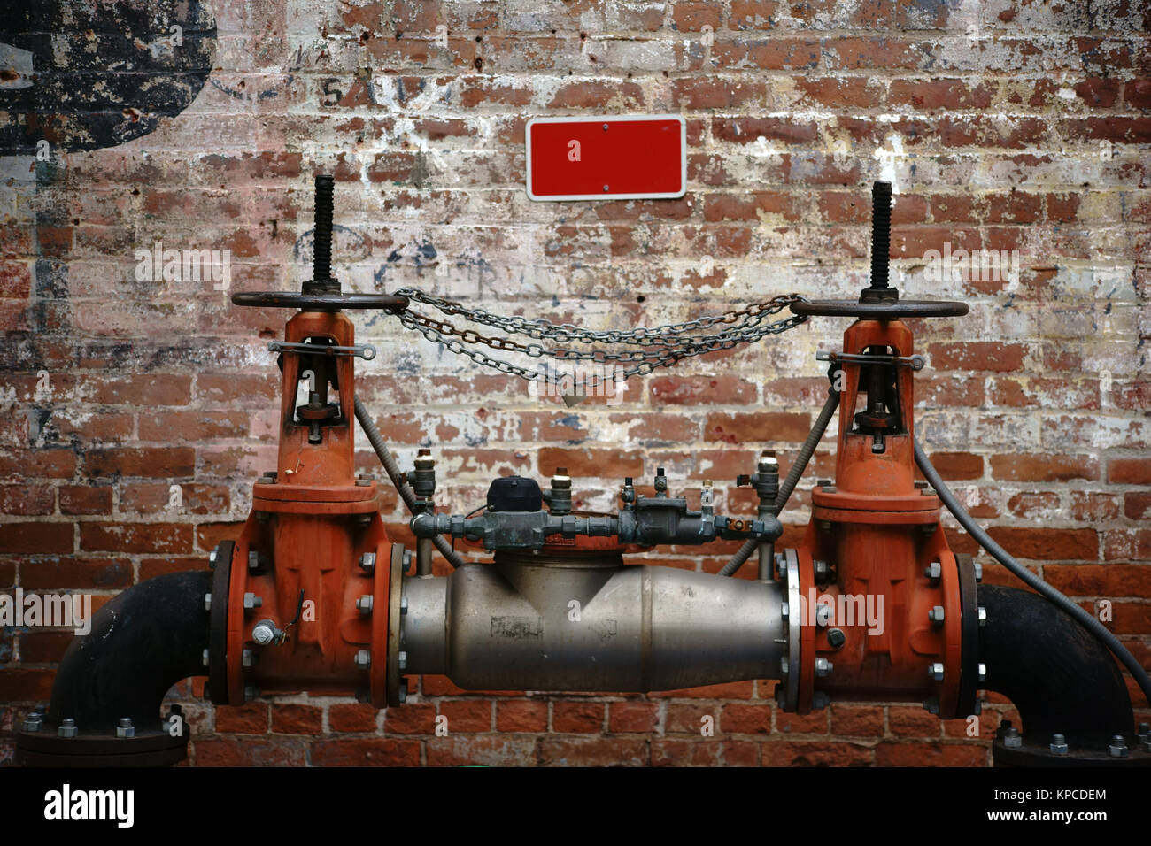 Eine Pumpstation steht vor einer alten Backsteinwand Farbschichten verblichenen Schriftzeichen und mit. Banque D'Images