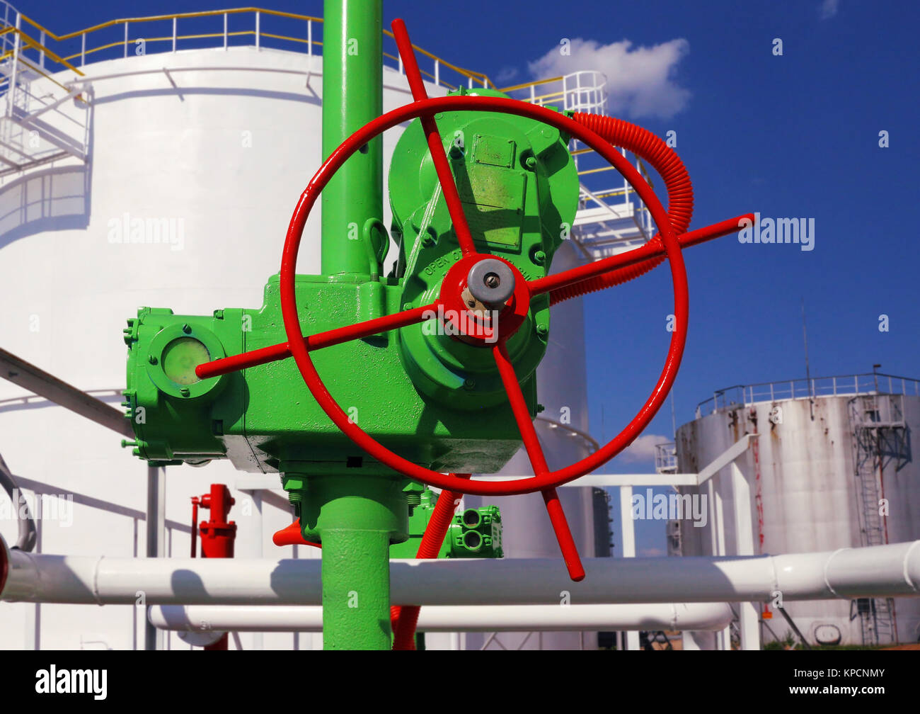 Distributeur vert sur un fond de réservoir de stockage de l'essence Banque D'Images