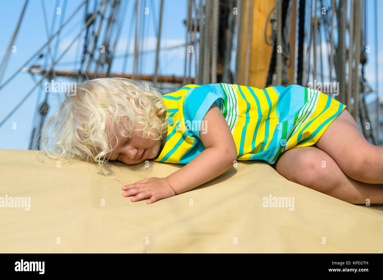 La petite fille s'endormit sur le pont d'un voilier Banque D'Images
