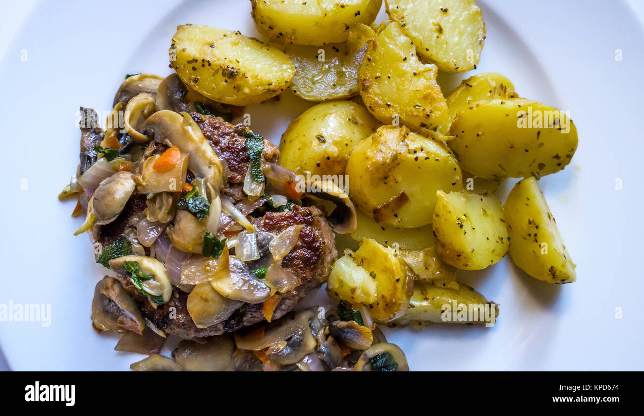 Steak haché avec une sauce à l'oignon et de champignons et pommes de terre sautées Banque D'Images