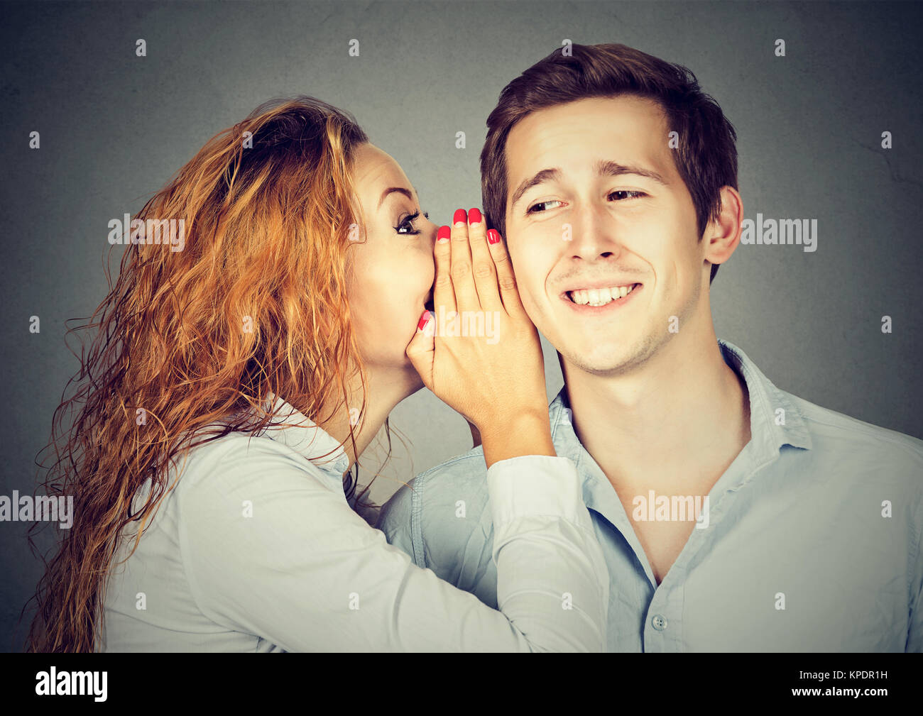Woman whispering nouvelles rumeurs de jeune homme écoute attentivement et avec intérêt. Banque D'Images