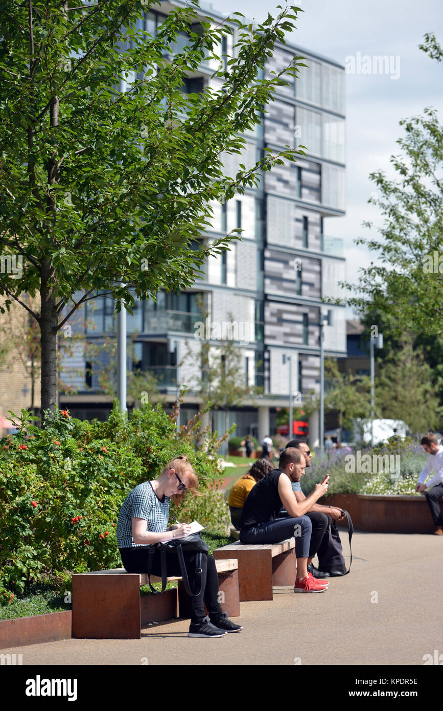 Les gens se détendre et profiter du soleil près de Central St Martins, Kings Cross Londres. Banque D'Images